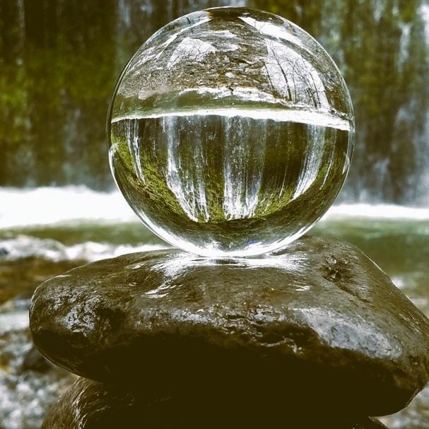 Water drop on a stone, reflecting a waterfall (the unconscious) in the background.